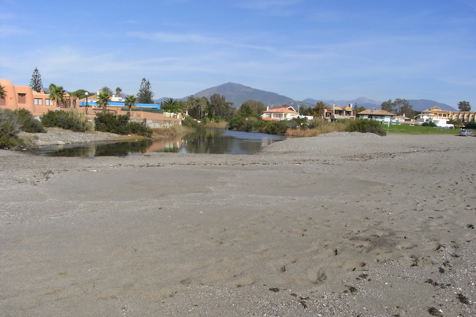 Guadalmina beach and river mouth with low villas and La Concha mountain in the distance
